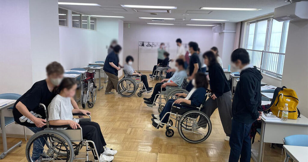 教室内で車椅子のサポートを学ぶ受講生達