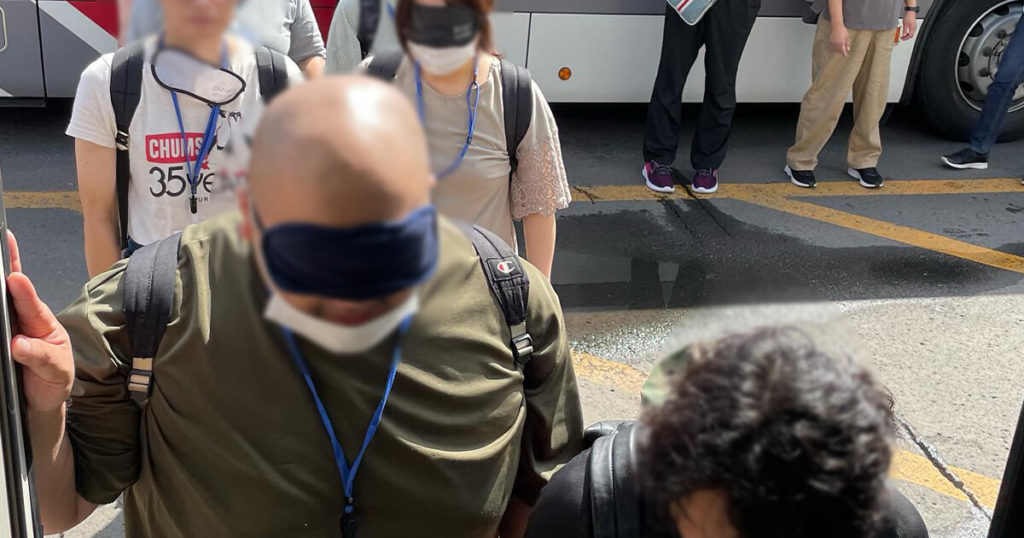 バスに乗り込むのをサポートする男性